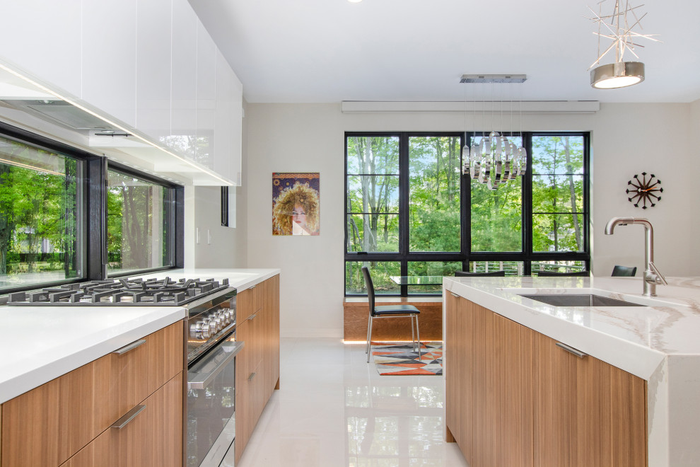 Bild på ett mellanstort funkis vit vitt kök, med en undermonterad diskho, släta luckor, skåp i ljust trä, bänkskiva i kvartsit, svart stänkskydd, fönster som stänkskydd, rostfria vitvaror, klinkergolv i porslin, en köksö och vitt golv