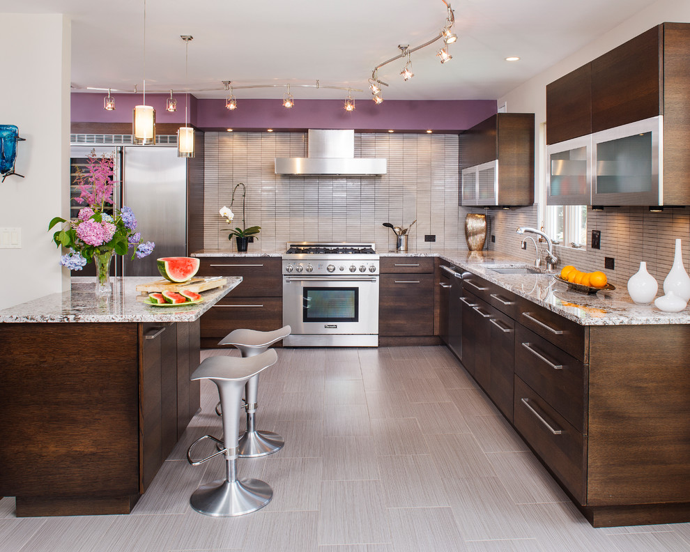 Kitchen - contemporary kitchen idea in New York with flat-panel cabinets, dark wood cabinets, beige backsplash and stainless steel appliances