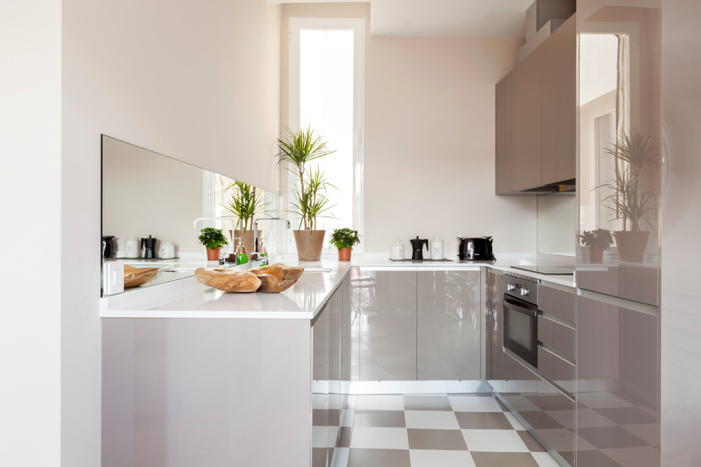 Идея дизайна: маленькая п-образная, отдельная кухня в современном стиле с плоскими фасадами, белыми фасадами, зеркальным фартуком и разноцветным полом без острова для на участке и в саду