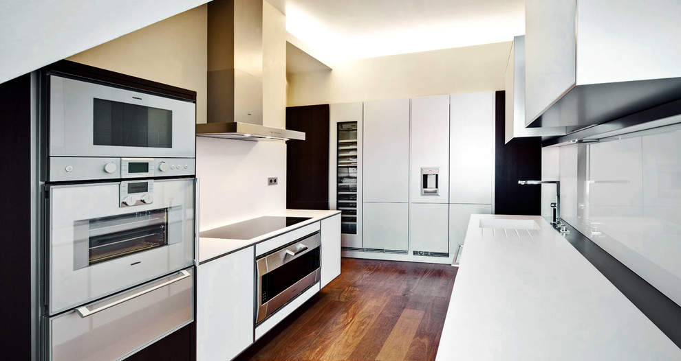 Moderne Küche ohne Insel mit Einbauwaschbecken, flächenbündigen Schrankfronten, weißen Schränken und Küchenrückwand in Weiß in Sonstige