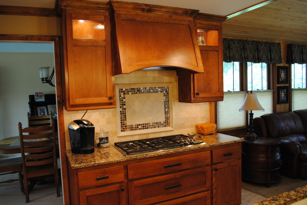 Classic kitchen in Minneapolis with flat-panel cabinets, medium wood cabinets, engineered stone countertops, beige splashback, stone tiled splashback, stainless steel appliances and an island.