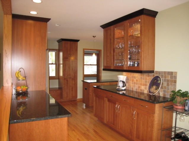 Mid-sized arts and crafts galley light wood floor eat-in kitchen photo in Minneapolis with an undermount sink, shaker cabinets, medium tone wood cabinets, quartz countertops, brown backsplash, subway tile backsplash, stainless steel appliances and an island