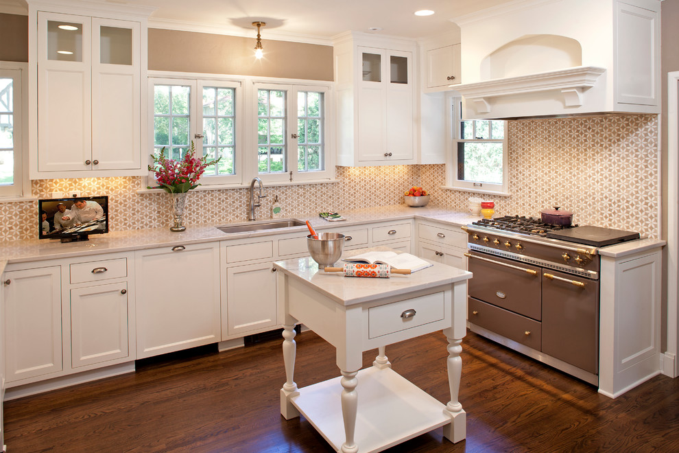 Exempel på ett mellanstort klassiskt u-kök, med en undermonterad diskho, luckor med infälld panel, vita skåp, marmorbänkskiva, vitt stänkskydd, stänkskydd i mosaik, integrerade vitvaror, mörkt trägolv och en köksö