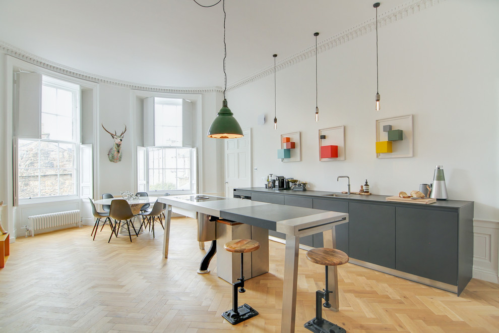 Foto på ett stort eklektiskt grå kök med öppen planlösning, med laminatbänkskiva, en köksö, en enkel diskho, släta luckor, grå skåp, ljust trägolv och beiget golv