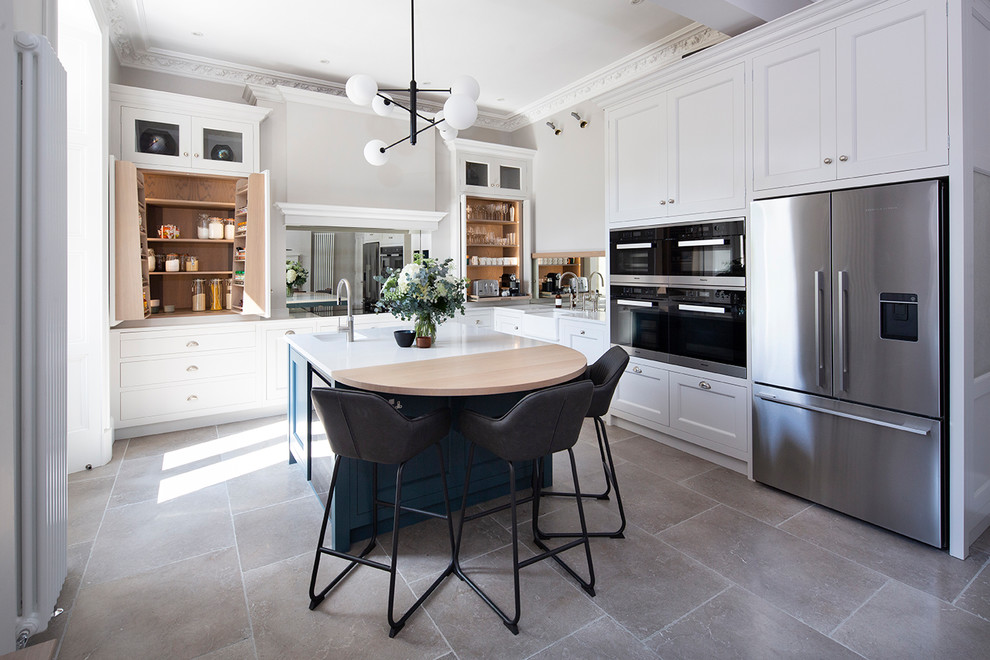 Design ideas for a large classic l-shaped kitchen in Edinburgh with a belfast sink, beaded cabinets, white cabinets, quartz worktops, mirror splashback, stainless steel appliances, an island, white worktops and grey floors.