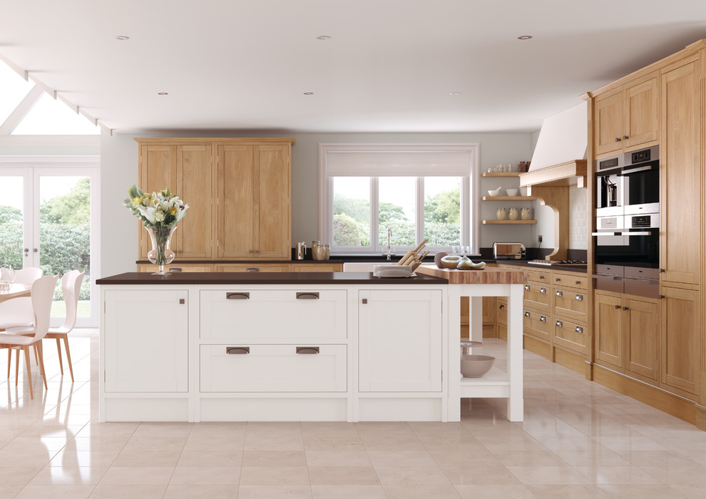 Photo of a large traditional l-shaped kitchen/diner in Other with a belfast sink, shaker cabinets, light wood cabinets and an island.