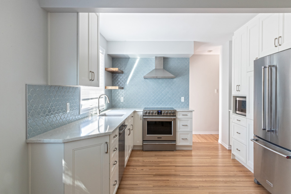 This is an example of a small classic l-shaped kitchen/diner in Edmonton with a submerged sink, shaker cabinets, white cabinets, granite worktops, blue splashback, ceramic splashback, stainless steel appliances, no island, brown floors, white worktops and medium hardwood flooring.