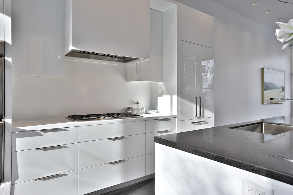 Immagine di una cucina moderna di medie dimensioni con lavello sottopiano, ante lisce, ante bianche, top in onice, paraspruzzi bianco, paraspruzzi con lastra di vetro, elettrodomestici in acciaio inossidabile, pavimento in legno massello medio e pavimento grigio