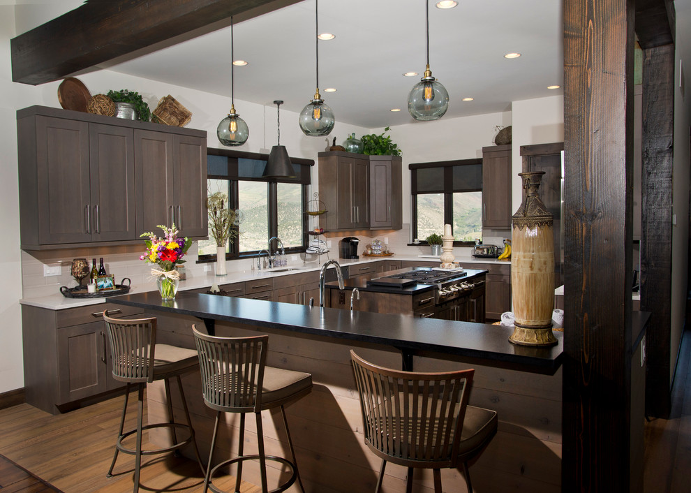 Eat-in kitchen - large transitional u-shaped medium tone wood floor eat-in kitchen idea in Denver with an undermount sink, recessed-panel cabinets, gray cabinets, quartz countertops, white backsplash, ceramic backsplash, stainless steel appliances and two islands