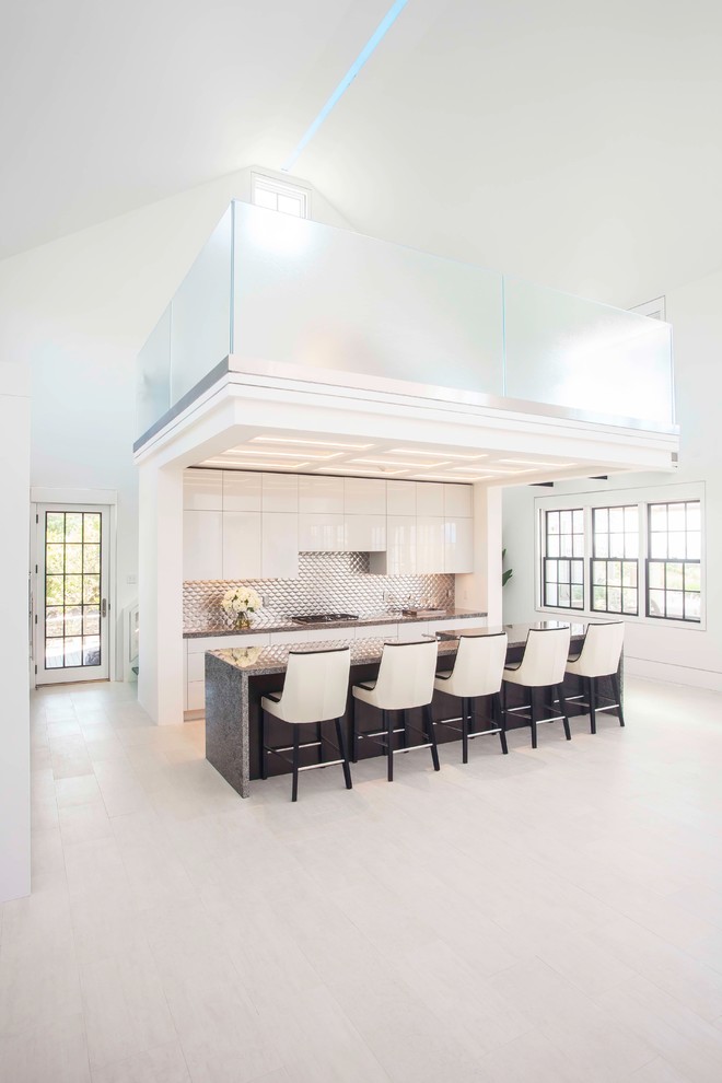 Exempel på ett stort modernt kök, med släta luckor, vita skåp, granitbänkskiva, stänkskydd med metallisk yta, rostfria vitvaror, ljust trägolv och en köksö