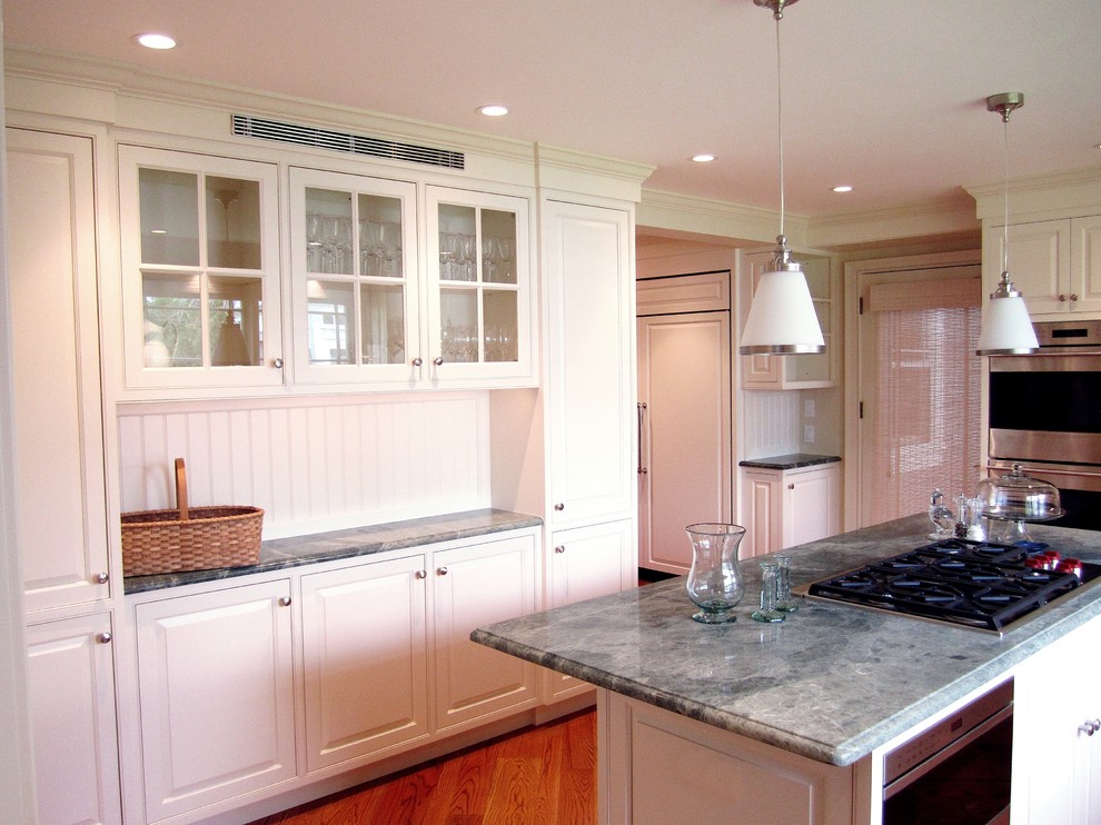 Example of a mid-sized classic l-shaped medium tone wood floor kitchen pantry design in Other with an undermount sink, beaded inset cabinets, white cabinets, granite countertops, white backsplash, paneled appliances and an island