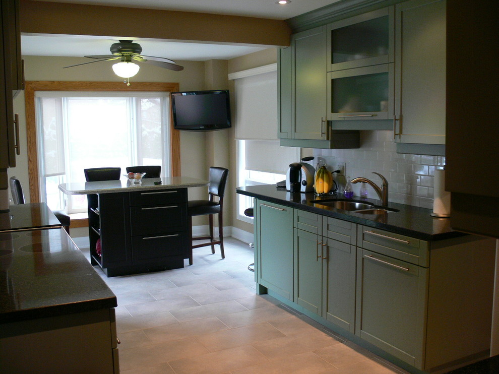 This is an example of a large contemporary u-shaped enclosed kitchen in Toronto with a double-bowl sink, shaker cabinets, green cabinets, granite worktops, white splashback, glass tiled splashback, white appliances, porcelain flooring and an island.
