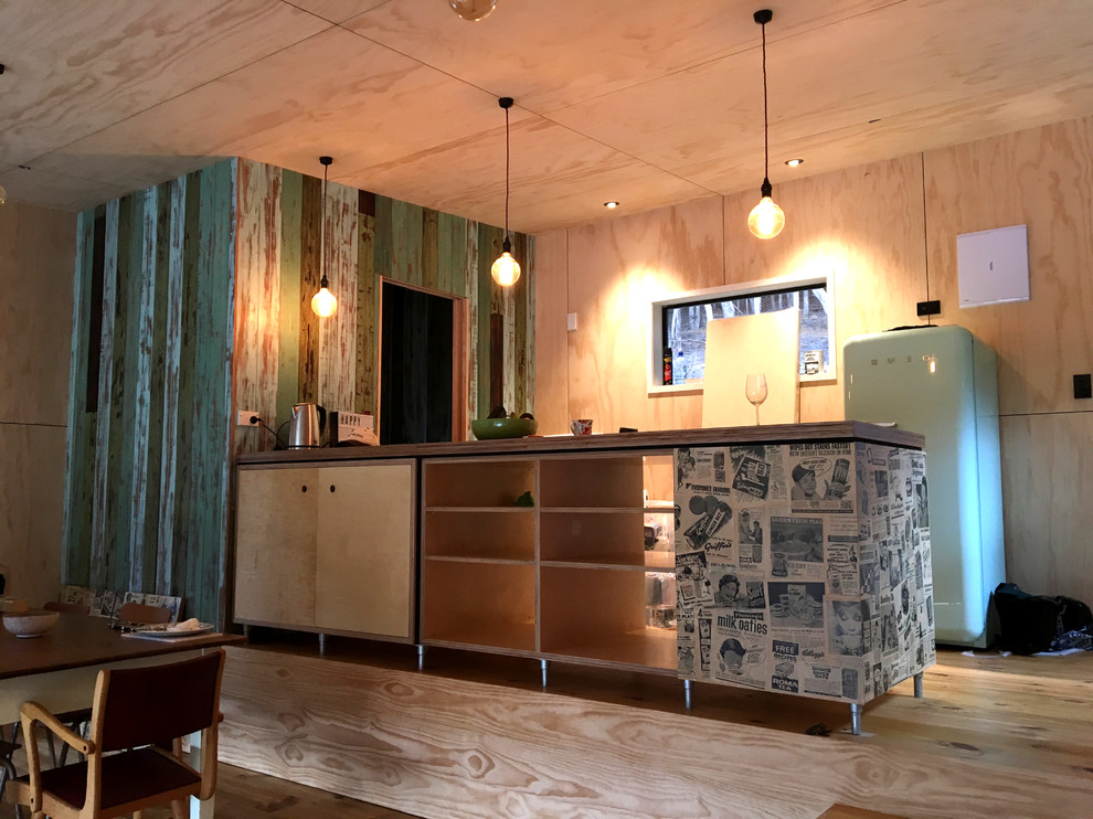 Idée de décoration pour une petite cuisine américaine linéaire marine en bois clair avec un placard sans porte, un plan de travail en bois, un électroménager de couleur et îlot.