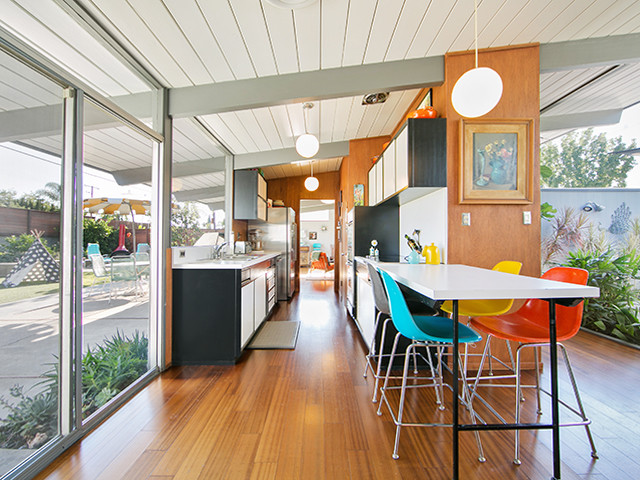 Inspiration for a medium sized midcentury galley kitchen/diner in Orange County with white cabinets, stainless steel appliances, medium hardwood flooring and no island.