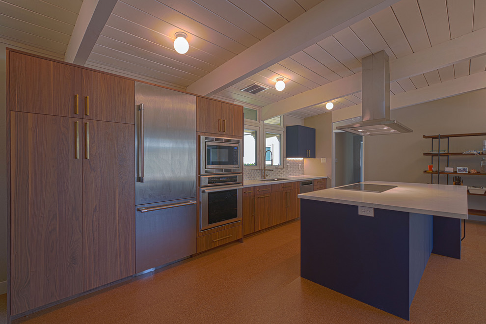 Foto di una cucina minimalista di medie dimensioni con lavello sottopiano, ante lisce, ante blu, top in quarzite, paraspruzzi bianco, paraspruzzi con piastrelle in ceramica, elettrodomestici in acciaio inossidabile, pavimento in sughero, pavimento arancione e top bianco