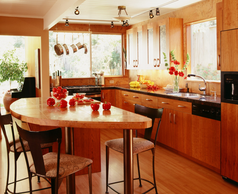 サンフランシスコにあるコンテンポラリースタイルのおしゃれなキッチン (フラットパネル扉のキャビネット、中間色木目調キャビネット、御影石カウンター、オレンジのキッチンパネル) の写真