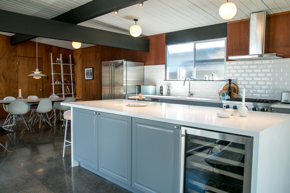 Eat-in kitchen - mid-sized mid-century modern single-wall concrete floor eat-in kitchen idea in San Francisco with an integrated sink, recessed-panel cabinets, gray cabinets, quartzite countertops, white backsplash, ceramic backsplash, stainless steel appliances and an island