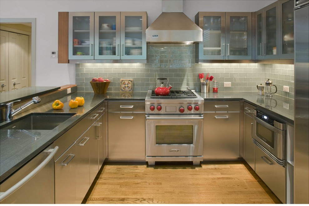 Inspiration for a contemporary u-shaped kitchen remodel in New York with subway tile backsplash, a single-bowl sink, flat-panel cabinets, gray backsplash, stainless steel appliances and stainless steel cabinets