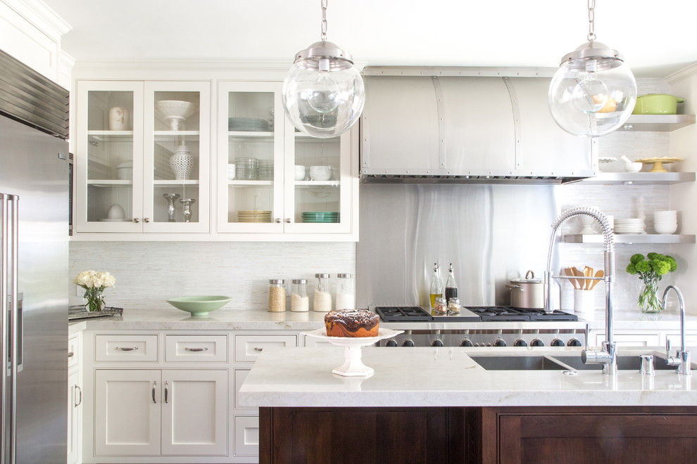 Eat-in kitchen - mid-sized traditional l-shaped medium tone wood floor eat-in kitchen idea in Los Angeles with an undermount sink, beaded inset cabinets, white cabinets, white backsplash, stainless steel appliances, an island, marble countertops and stone tile backsplash