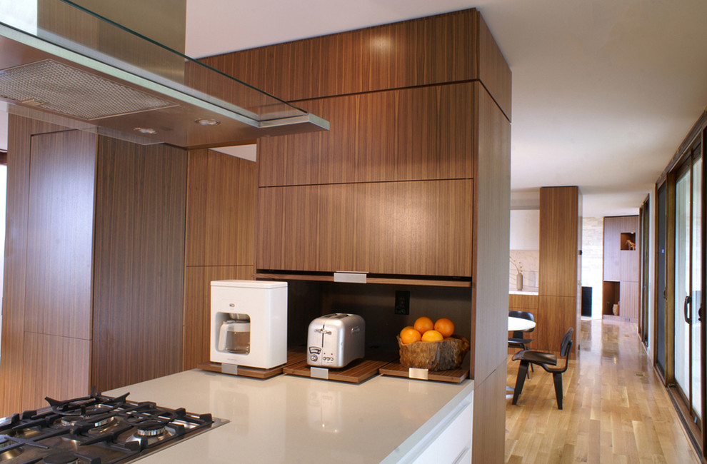 This is an example of a large modern l-shaped kitchen/diner in San Francisco with flat-panel cabinets, medium wood cabinets, marble worktops, light hardwood flooring and a breakfast bar.