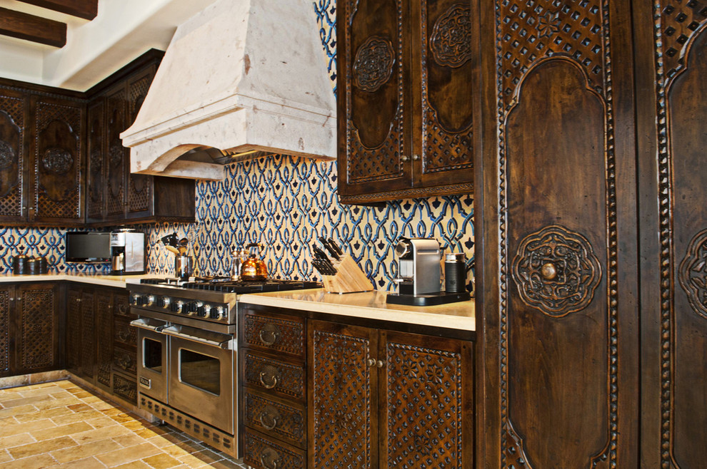 Идея дизайна: кухня в средиземноморском стиле с темными деревянными фасадами, разноцветным фартуком, техникой из нержавеющей стали и красивой плиткой