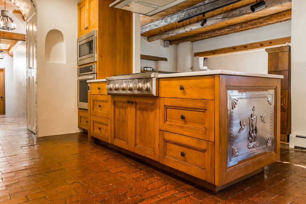 Eat-in kitchen - mid-sized southwestern brick floor and red floor eat-in kitchen idea in Albuquerque with an undermount sink, shaker cabinets, medium tone wood cabinets, quartz countertops, multicolored backsplash, porcelain backsplash, stainless steel appliances, a peninsula and beige countertops