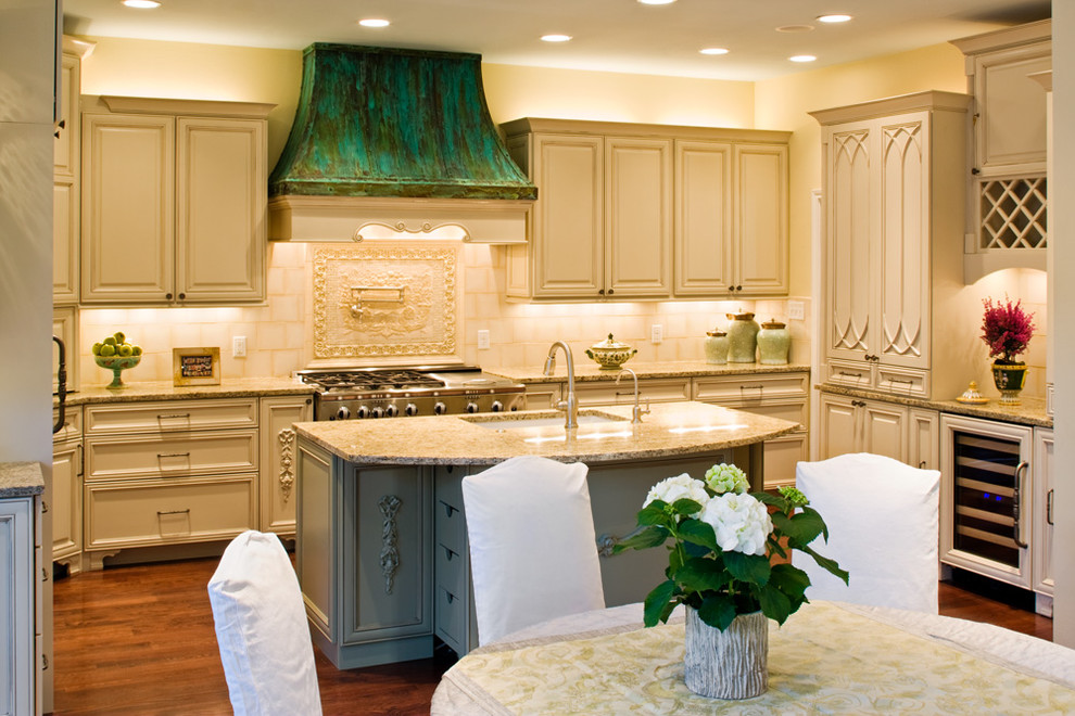 Inredning av ett klassiskt kök och matrum, med en undermonterad diskho, luckor med upphöjd panel, beige skåp, granitbänkskiva och beige stänkskydd