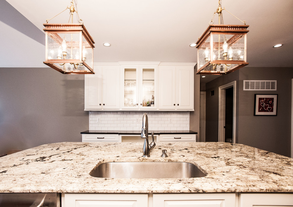 Klassische Küche in U-Form mit Triple-Waschtisch, weißen Schränken, Granit-Arbeitsplatte, Küchenrückwand in Weiß und Kücheninsel in Kansas City