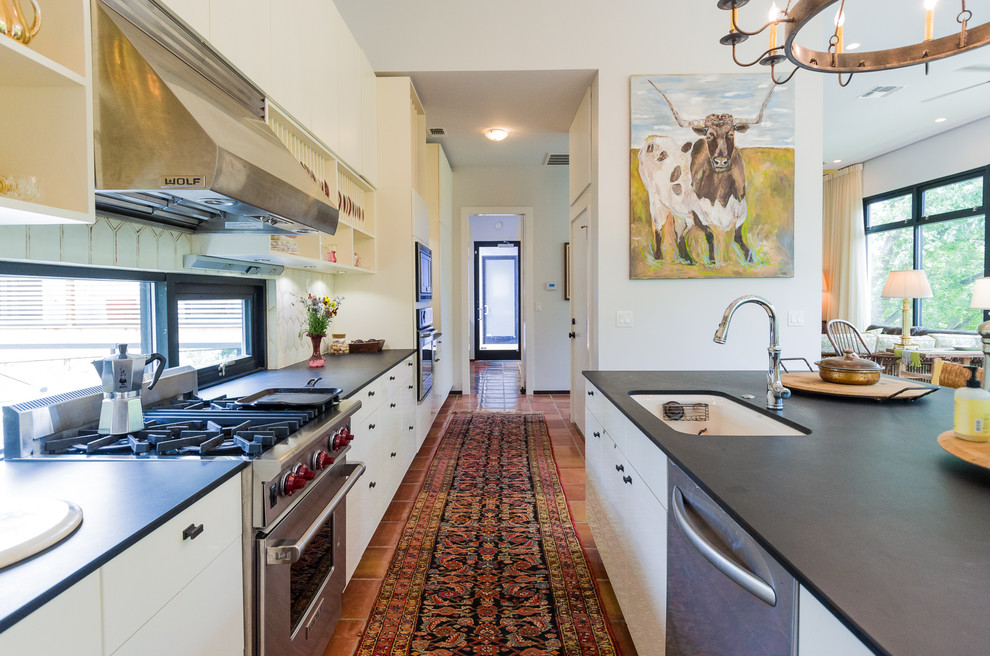 Transitional kitchen photo in Austin with flat-panel cabinets, white cabinets, white backsplash and stainless steel appliances