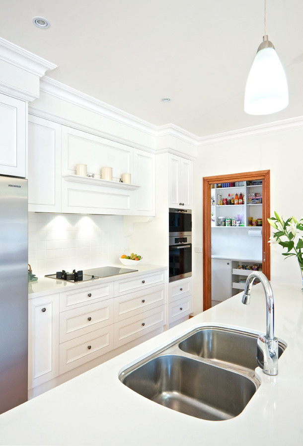 Medium sized classic single-wall kitchen in Melbourne with a double-bowl sink, shaker cabinets, white cabinets, quartz worktops, white splashback, ceramic splashback, dark hardwood flooring, an island and white worktops.