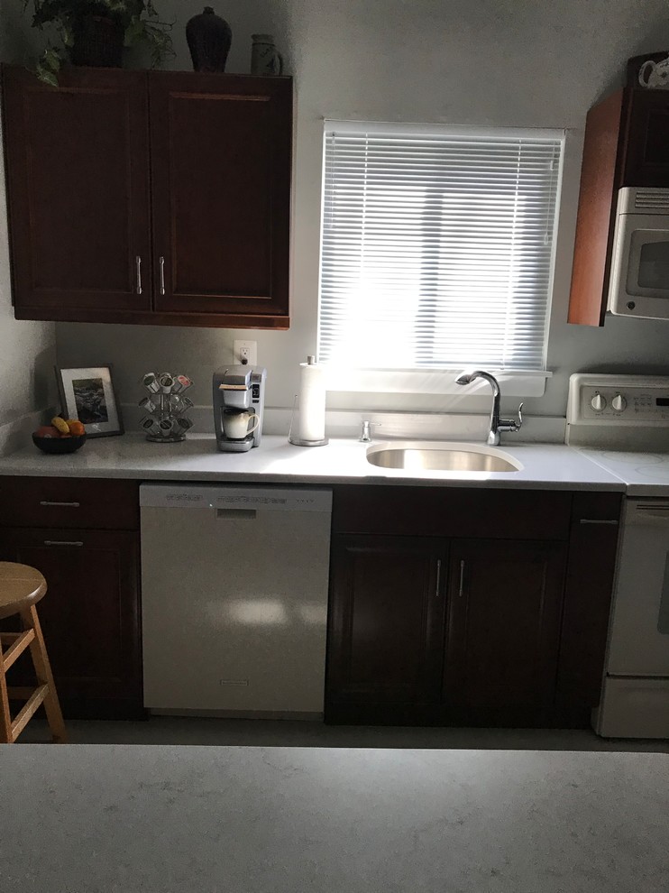 Kleine Klassische Wohnküche in L-Form mit Unterbauwaschbecken, dunklen Holzschränken, Quarzwerkstein-Arbeitsplatte, weißen Elektrogeräten, Kücheninsel, gelbem Boden und weißer Arbeitsplatte in Baltimore
