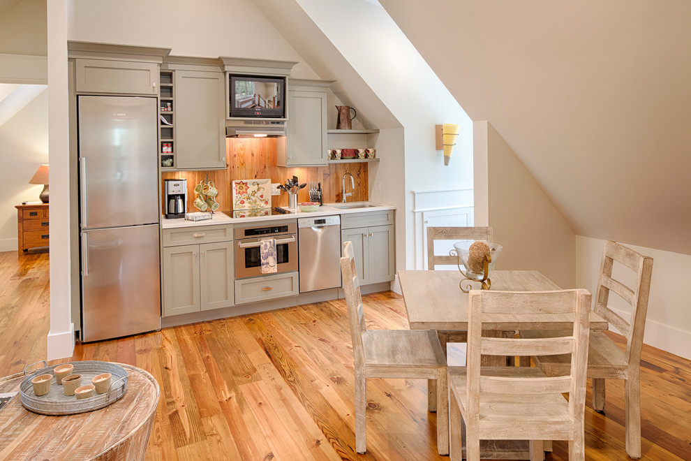 Bild på ett mellanstort lantligt linjärt kök och matrum, med en undermonterad diskho, luckor med infälld panel, grå skåp, marmorbänkskiva, brunt stänkskydd, rostfria vitvaror och mellanmörkt trägolv
