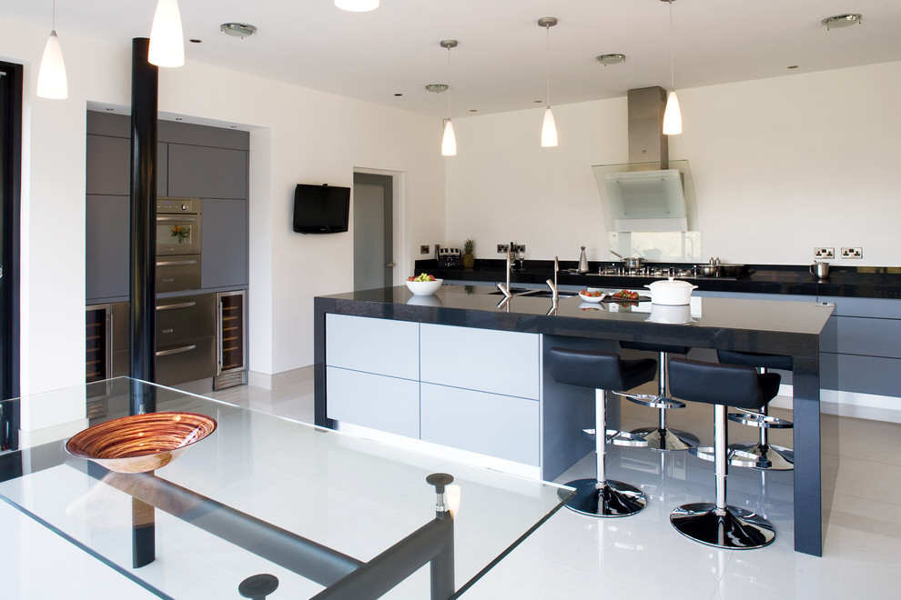 Moderne Küche mit Küchengeräten aus Edelstahl und grauen Schränken in Sonstige