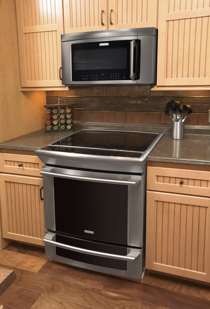 Foto di una cucina stile marinaro con elettrodomestici in acciaio inossidabile e ante in legno chiaro