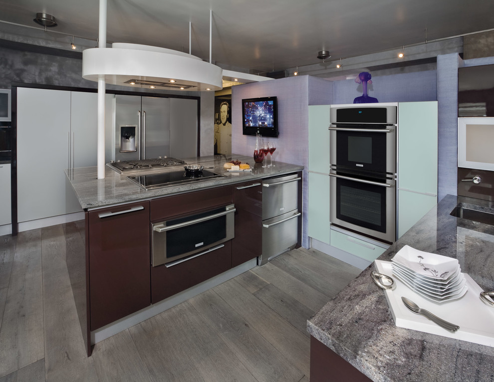 Photo of a small contemporary u-shaped kitchen/diner in Atlanta with flat-panel cabinets, brown cabinets, granite worktops, stainless steel appliances, medium hardwood flooring, an island and grey floors.