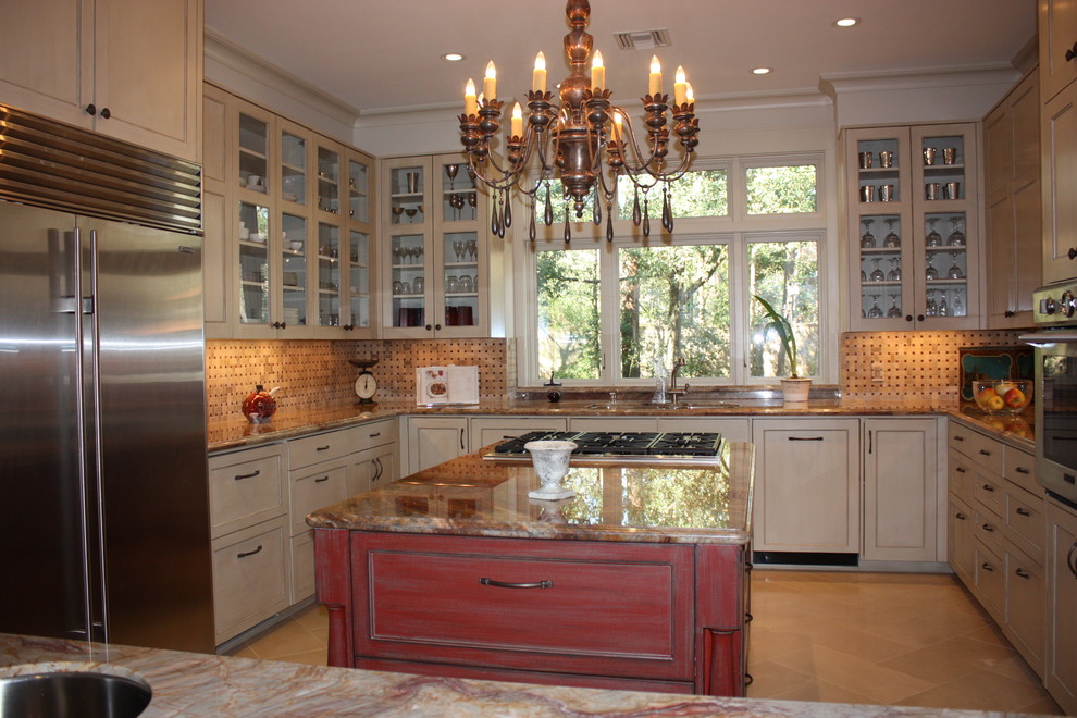 Bild på ett stort vintage kök, med luckor med infälld panel, beige skåp, granitbänkskiva, beige stänkskydd, stänkskydd i mosaik, rostfria vitvaror, kalkstensgolv och en köksö