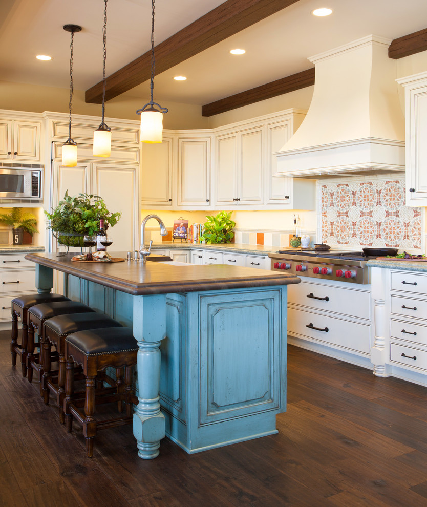 Landhausstil Küche mit profilierten Schrankfronten, weißen Schränken, Küchengeräten aus Edelstahl, braunem Holzboden und Kücheninsel in San Diego
