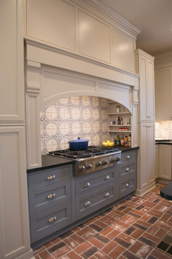 Idéer för mellanstora vintage l-kök, med en undermonterad diskho, luckor med infälld panel, rostfria vitvaror, tegelgolv och en köksö