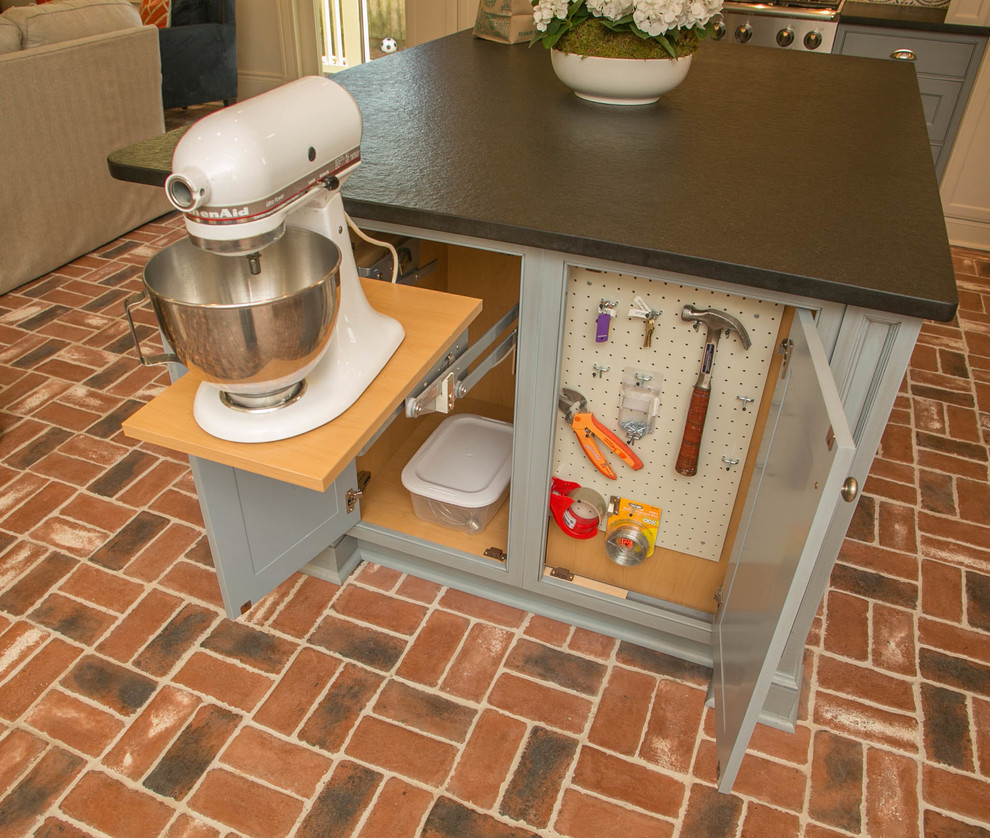 Idee per una cucina chic di medie dimensioni con lavello sottopiano, ante con riquadro incassato, elettrodomestici in acciaio inossidabile e pavimento in mattoni