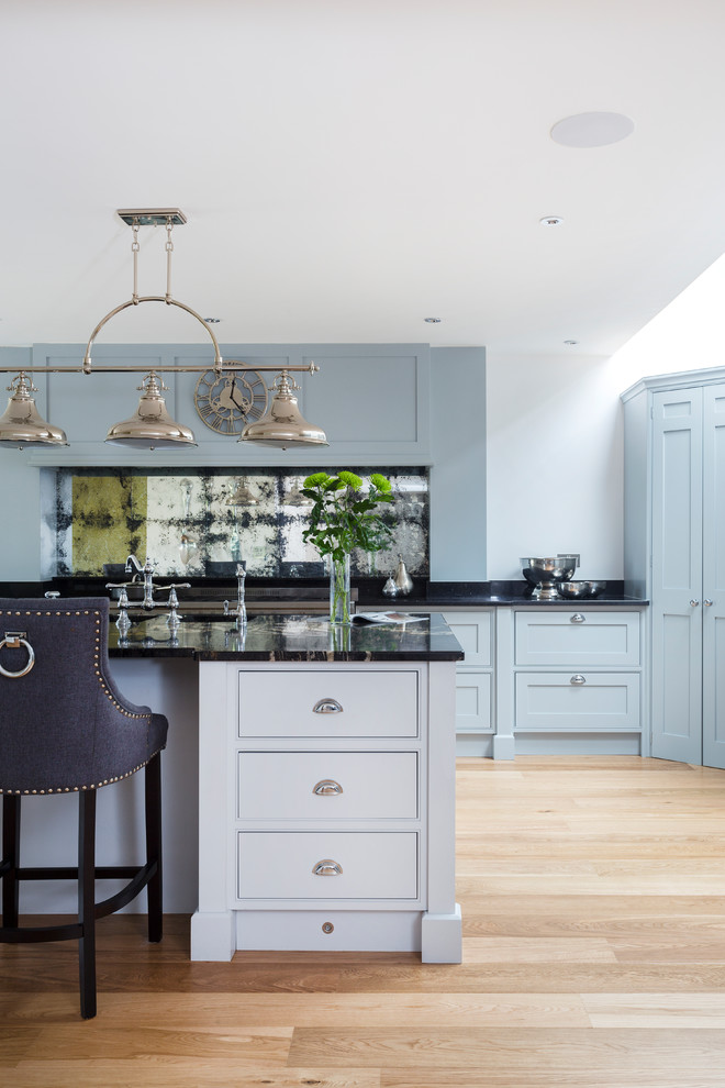 This is an example of a large traditional kitchen/diner in Kent with beaded cabinets, grey cabinets, granite worktops, metallic splashback, mirror splashback, stainless steel appliances, medium hardwood flooring, an island and a submerged sink.