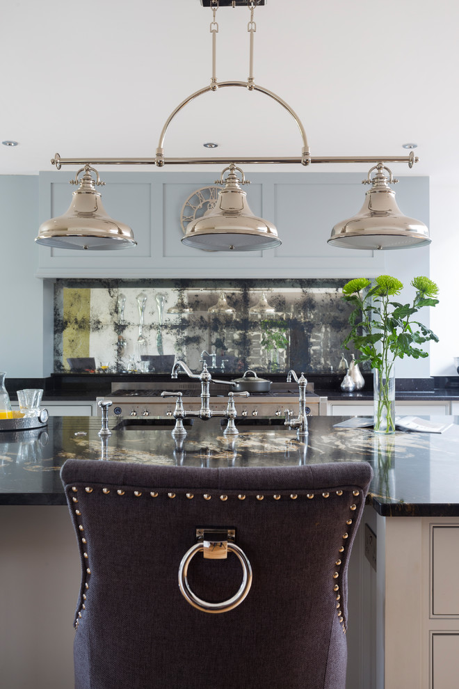 Bild på ett stort vintage kök och matrum, med luckor med profilerade fronter, grå skåp, granitbänkskiva, stänkskydd med metallisk yta, spegel som stänkskydd, rostfria vitvaror, mellanmörkt trägolv, en köksö och en undermonterad diskho