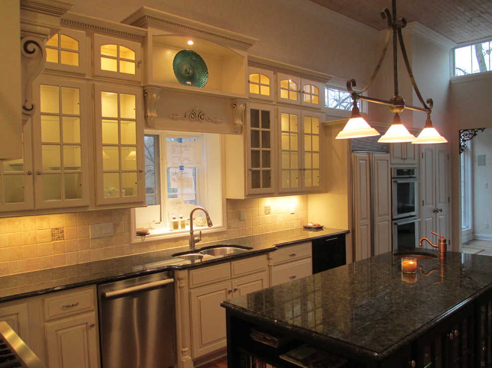 Modelo de cocina comedor clásica con fregadero bajoencimera, puertas de armario blancas, encimera de granito y salpicadero beige