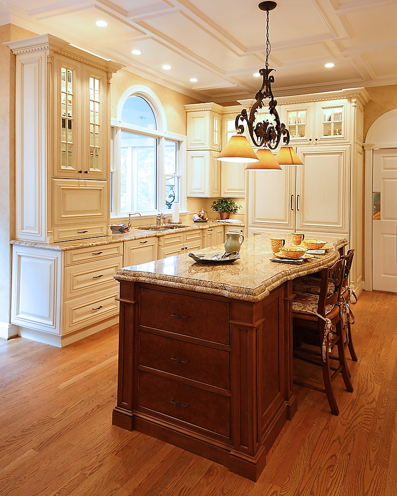 Design ideas for a large classic l-shaped kitchen/diner in Baltimore with a double-bowl sink, raised-panel cabinets, beige cabinets, granite worktops, integrated appliances, medium hardwood flooring and an island.