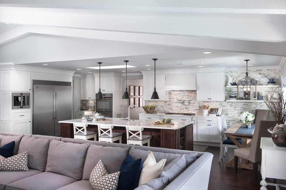 Inspiration for a large transitional u-shaped dark wood floor open concept kitchen remodel in Orlando with an island, a farmhouse sink, recessed-panel cabinets, white cabinets, quartzite countertops, gray backsplash, stone tile backsplash and stainless steel appliances
