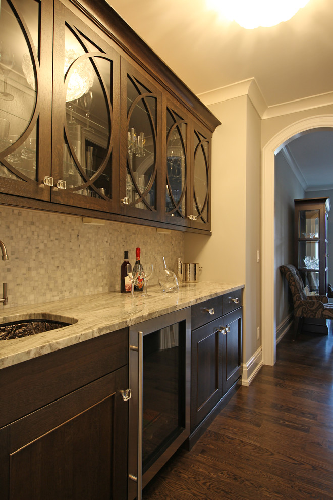 This is an example of an expansive traditional u-shaped home bar in Detroit with a submerged sink, shaker cabinets, white cabinets, engineered stone countertops, white splashback, stone tiled splashback, dark hardwood flooring, brown floors and grey worktops.