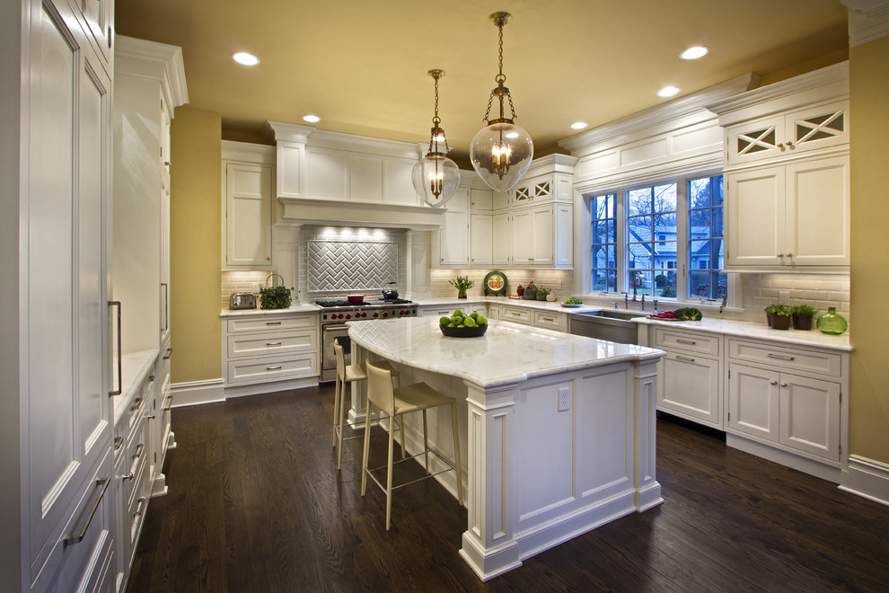 Example of a classic kitchen design in New York with a farmhouse sink, recessed-panel cabinets, white cabinets, white backsplash, subway tile backsplash and stainless steel appliances
