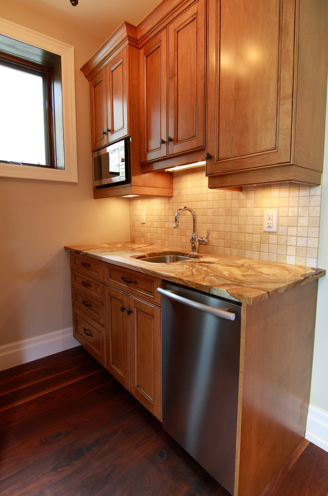 This is an example of a small classic galley kitchen in Toronto with an island, light wood cabinets, stainless steel appliances and dark hardwood flooring.