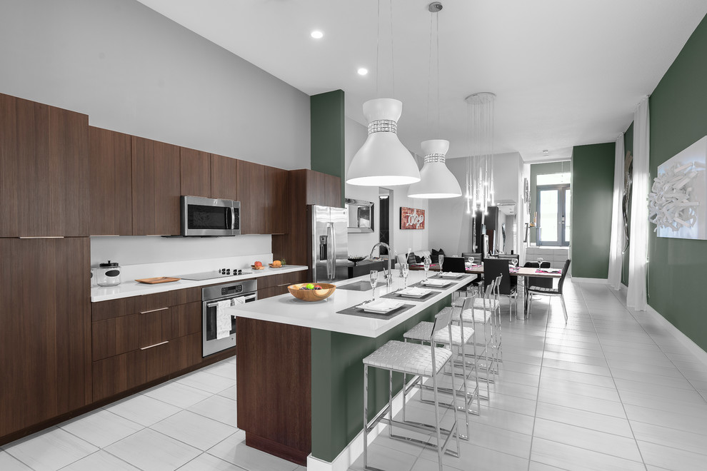 Moderne Küche mit Unterbauwaschbecken, flächenbündigen Schrankfronten, dunklen Holzschränken, Quarzit-Arbeitsplatte, Keramikboden, Kücheninsel, weißem Boden und weißer Arbeitsplatte in Miami
