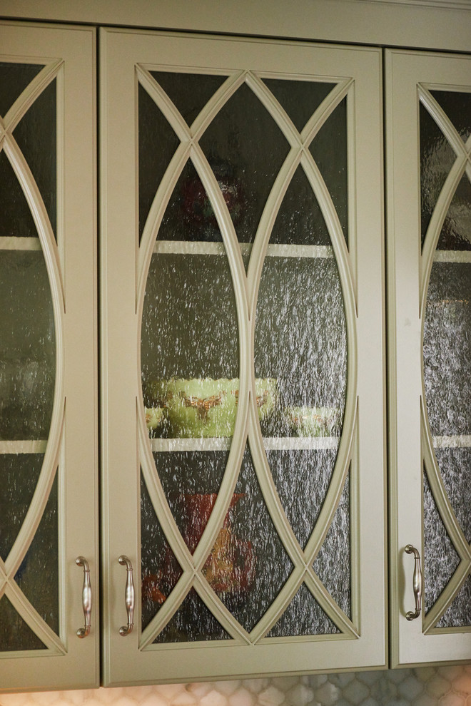 Exempel på ett avskilt, mellanstort klassiskt parallellkök, med en undermonterad diskho, gröna skåp, bänkskiva i kvartsit, vitt stänkskydd, stänkskydd i mosaik, rostfria vitvaror, mörkt trägolv och luckor med glaspanel