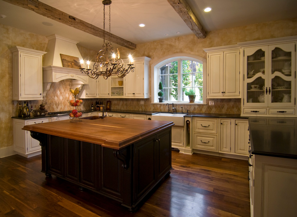 Exempel på ett klassiskt kök, med en rustik diskho, luckor med upphöjd panel, vita skåp, beige stänkskydd, mörkt trägolv och flera köksöar